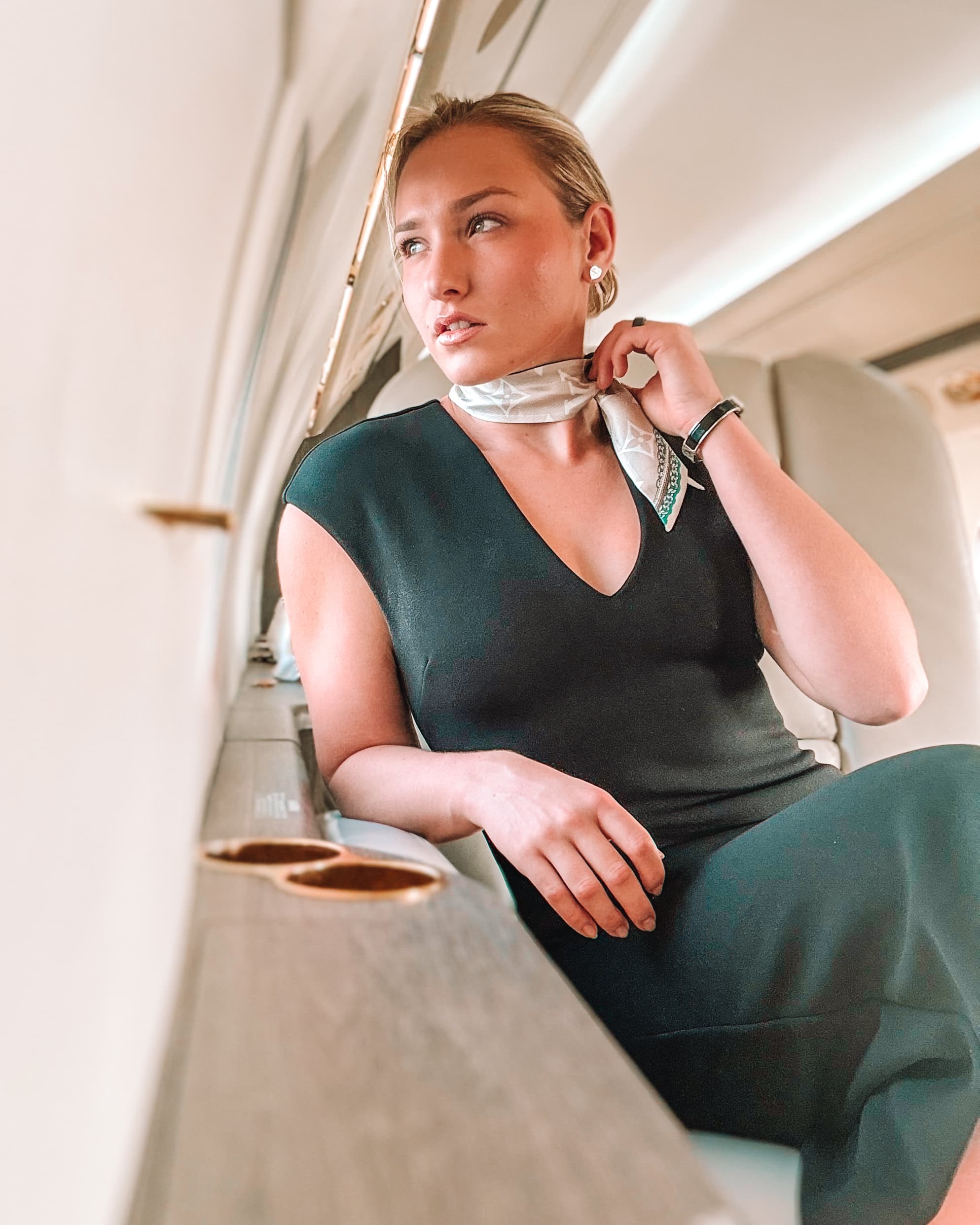 Mercedes in a neutral suit standing beside a private jet at golden hour